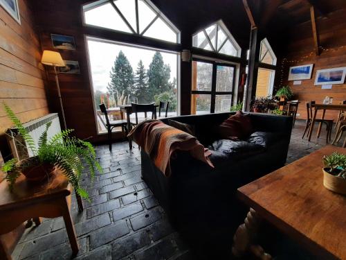 a living room with a black couch and a table at Hosteria La Luna in San Carlos de Bariloche