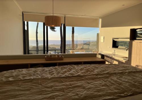 sypialnia z łóżkiem i dużym oknem w obiekcie ALMA Lodge w mieście Matanzas