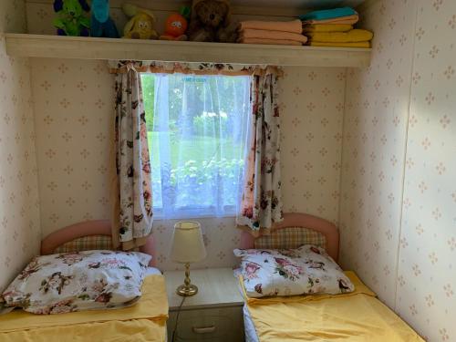 two beds in a room with a window at Kundziņi in Bīriņi