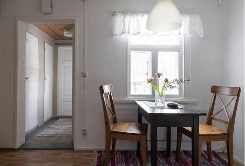 ein Esszimmer mit einem Tisch, Stühlen und einem Fenster in der Unterkunft Cozy cottage in quiet location in Oulu