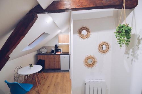 a kitchen with a table and two mirrors on the wall at Studios Lsquare Residence AFPA in Châtellerault