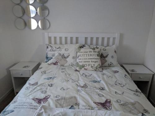 a bedroom with a bed with butterflies on it at Ecky-Thump pet friendly holiday chalet in Bridlington