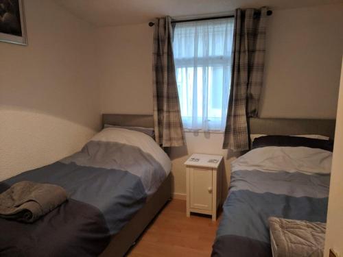 a small bedroom with two beds and a window at Ecky-Thump pet friendly holiday chalet in Bridlington