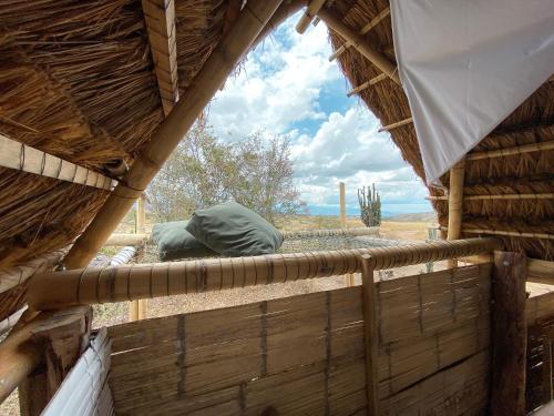 a view from the inside of a thatch hut with a window at biohotel tatacoa Qji in Villavieja