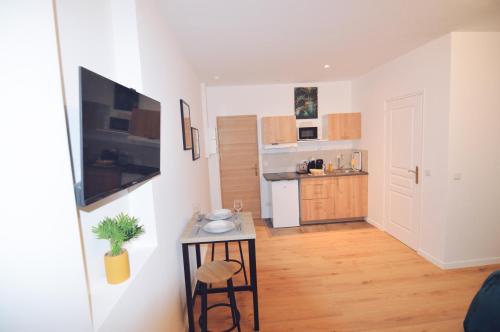 a small apartment with a small table and a kitchen at Studios Lsquare Residence AFPA in Châtellerault