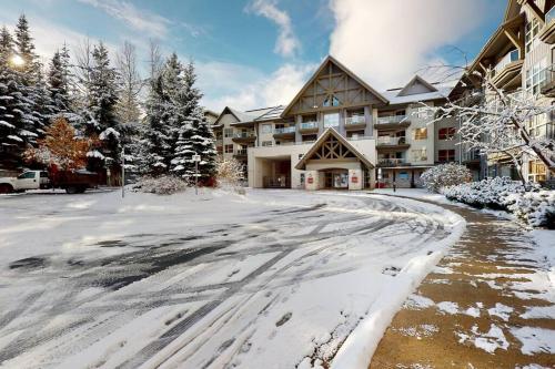 a snow covered street in front of a lodge at Aspens by WB Vacation Rentals in Whistler