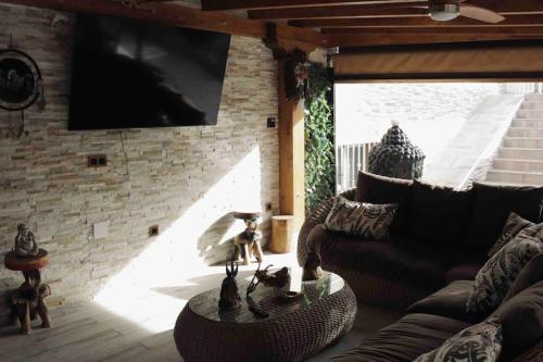 sala de estar con sofá y pared de ladrillo en Hacienda Cruz, en Toledo