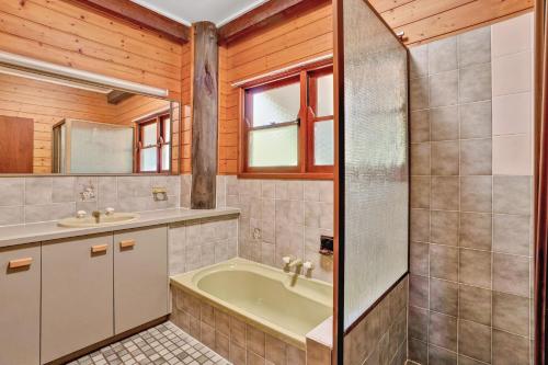 a bathroom with a tub and a sink at 41 Carlo Circle Rainbow Beach in Rainbow Beach