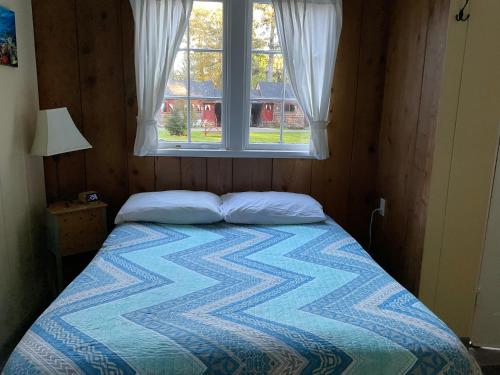 Ce lit se trouve dans une petite chambre dotée d'une fenêtre. dans l'établissement Shakti Cove Cottages, à Ocean Park