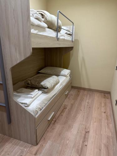 a bunk bed in a room with a wooden floor at Appartamento tra le montagne in Pescocostanzo