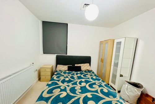 sypialnia z łóżkiem z niebiesko-białą kołdrą w obiekcie 1 Bed Stunning Central London Apartment City Road w Londynie