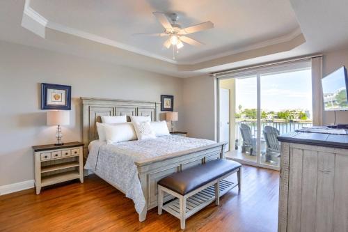 a bedroom with a bed with a ceiling fan and a balcony at 204 Bay Harbor in Clearwater Beach