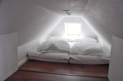 białe łóżko w pokoju z oknem w obiekcie Fewo Peeneblick_LINA w mieście Karlshagen