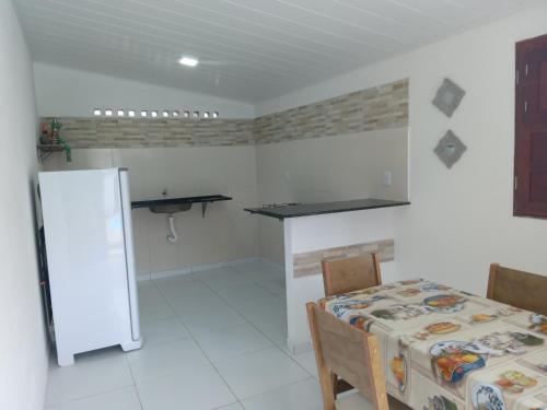 a white room with a table and a table and chairs at FRANCÊS FLATS in Marechal Deodoro