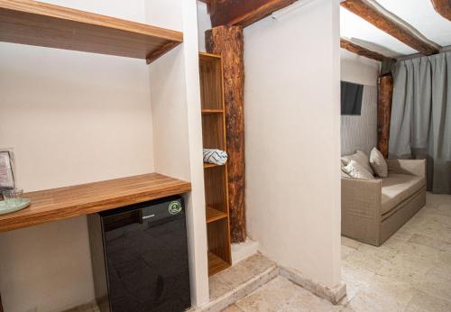a room with a tv and a living room at Amaite Holbox - Oceanfront Hotel in Holbox Island