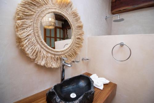 a bathroom with a black sink and a mirror at Amaite Holbox - Oceanfront Hotel in Holbox Island