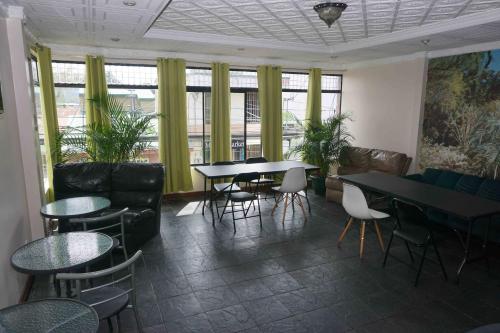 - une salle d'attente avec des tables, des chaises et des fenêtres dans l'établissement Hotel el Tucan Alajuela, à Alajuela