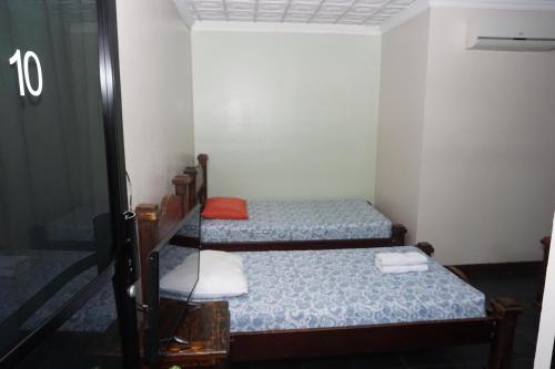 a small room with two beds and a mirror at Hotel el Tucan Alajuela in Alajuela City
