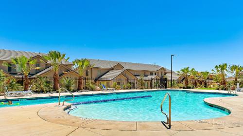 a large swimming pool with palm trees and houses at Zion Sunrise townhouse in Washington