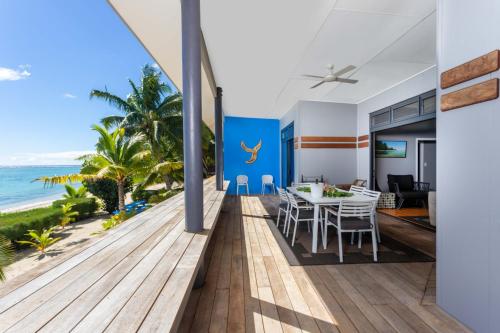 a dining room with a view of the ocean at Panama Beachfront Apartments, Rarotonga in Rarotonga