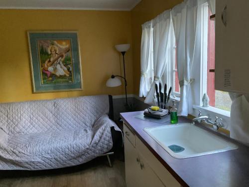 La salle de bains est pourvue d'un lavabo, d'un canapé et d'une fenêtre. dans l'établissement Shakti Cove Cottages, à Ocean Park