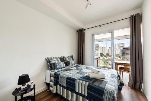 1 dormitorio con cama y ventana grande en EN11 Luxo no Brooklin: Sofisticação e Conforto, en São Paulo