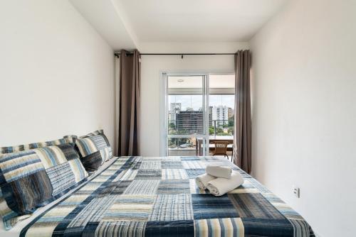 1 dormitorio con 1 cama con manta y ventana en EN11 Luxo no Brooklin: Sofisticação e Conforto, en São Paulo