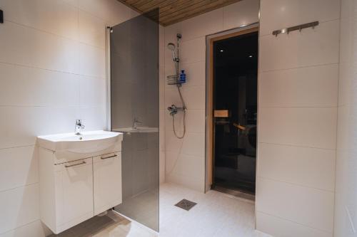 y baño blanco con lavabo y ducha. en Arctic Loft Rovaniemi, en Rovaniemi