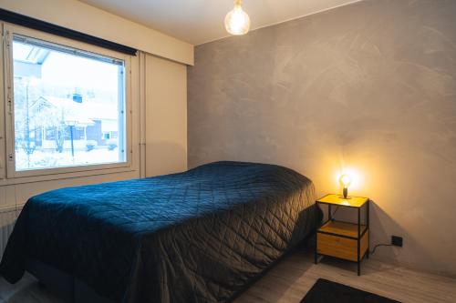 1 dormitorio con 1 cama y 1 lámpara en una mesa en Arctic Loft Rovaniemi, en Rovaniemi