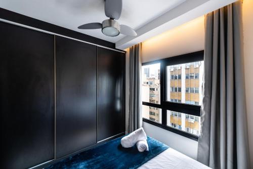 1 dormitorio con paredes negras y 1 cama con ventana en Mi1209 Studio Moderno Prox Paulista e Parque Augusta, en São Paulo