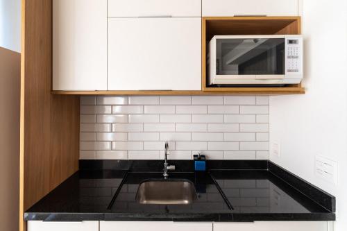 uma cozinha com um lavatório e um micro-ondas em VO13 - Apto Luxuoso e Aconchegante no Bom Retiro: Conforto em São Paulo