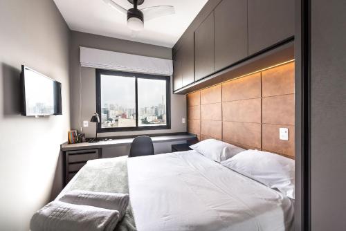 Un dormitorio con una gran cama blanca y una ventana en AA1705 - Apto 1 Quarto Aconchegante perto da Av. Paulista, Bela Vista., en São Paulo