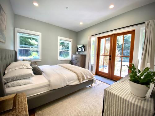 um quarto com uma cama grande e uma porta de vidro deslizante em Modern Farmhouse Wooded Hide Away em McKinleyville