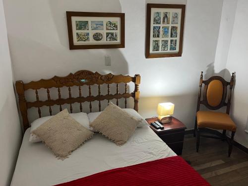 a bedroom with a bed with a lamp and a chair at Casa Grande in Medellín