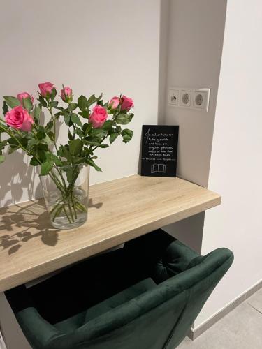 a vase of pink roses sitting on a table at Palm Premium Hotel & Apartments in Düsseldorf