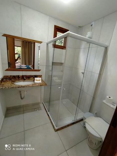 a bathroom with a glass shower and a toilet at Vila Hen Praia do Forte - Studios com Varanda e Piscina - Quintas do Castelo da Torre - Reserva Sapiranga - 3,6km da Vila in Praia do Forte