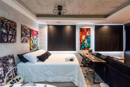 1 dormitorio con 1 cama y escritorio con ordenador en AA212 Studio aconchegante c/ vaga de garagem, en São Paulo