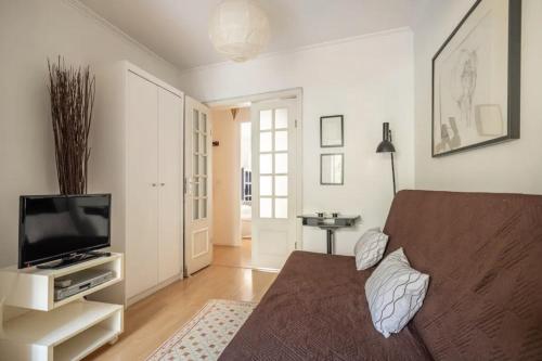 ein Wohnzimmer mit einem Sofa und einem Flachbild-TV in der Unterkunft Jardin d'Olisipo - Centre Ville in Lissabon