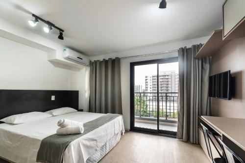 1 dormitorio con cama y ventana grande en IA5 - Studio Incrível e Moderno em Moema, Totalmente Equipado., en São Paulo