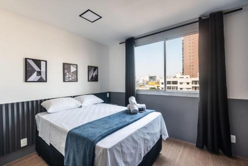 1 dormitorio con cama y ventana grande en MV46A - Studio Próximo à Estação Brás: Conforto Garantido, en São Paulo