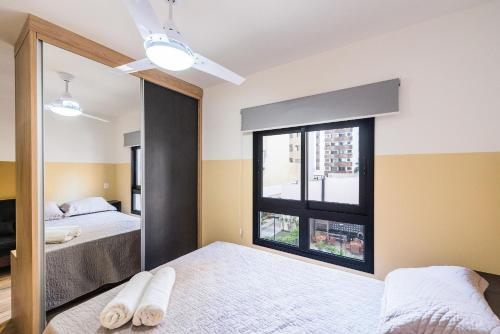 1 dormitorio con 2 camas y ventana grande en MI511 - Studio Aconchegante para 4 Pessoas Próximo ao Parque Augusta, en São Paulo