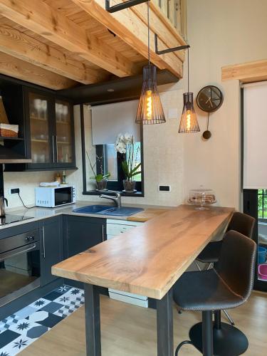 a kitchen with a wooden table and two chairs at Ca de Palomera Vall d’Aran in Les