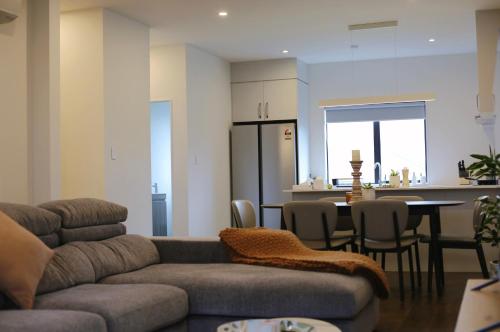 a living room with a couch and a table and a kitchen at Cheerful 3-bedroom townhouse close to the city in Auckland
