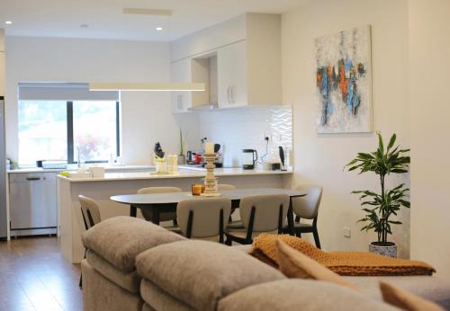 a kitchen and a living room with a couch and a table at Cheerful 3-bedroom townhouse close to the city in Auckland