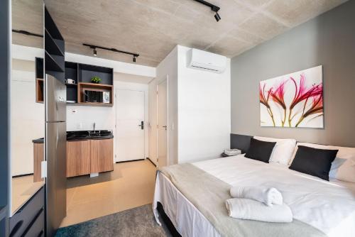 1 dormitorio con 1 cama grande y cocina en VNF917 - Studio Aconchegante: Próximo ao Shopping Frei Caneca e Av. Paulista, en São Paulo