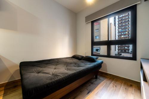 Cama en habitación con ventana en MI611 - Studio Aconchegante para 4 Pessoas Próximo ao Parque Augusta, en São Paulo