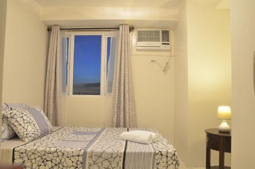 Un pat sau paturi într-o cameră la Gilmore Apartment at Princeton Residences Condominium