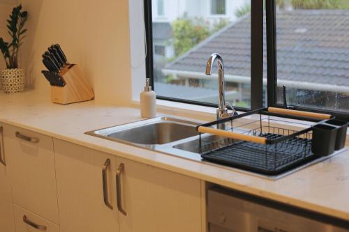 a kitchen counter with a sink and a window at Cozy and comfortable, sunny three-storey building in Auckland