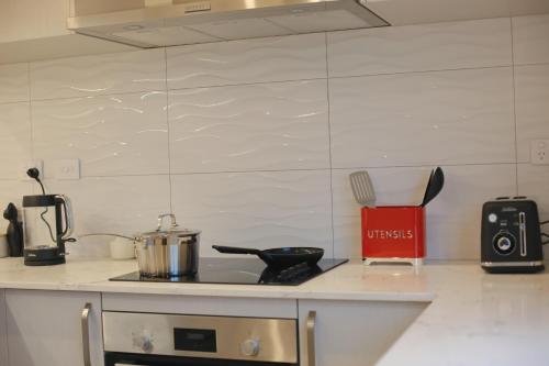 a kitchen counter with a stove with a pot on it at Cozy and comfortable, sunny three-storey building in Auckland