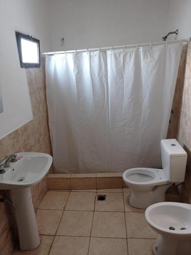 y baño con aseo blanco y lavamanos. en The One en Tupungato
